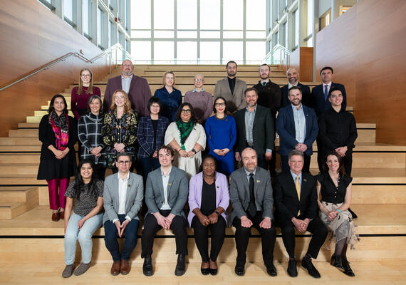 2024 Teaching Awards recipients sitting on the stairs inside the Taylor Institute for Teaching and Learning.